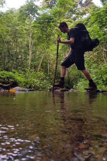 Walking over a river on the Kokoda Trail